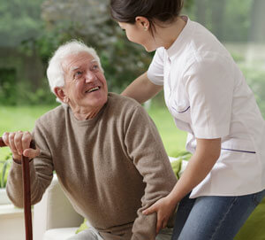 Elderly man with cane being helped by physician
